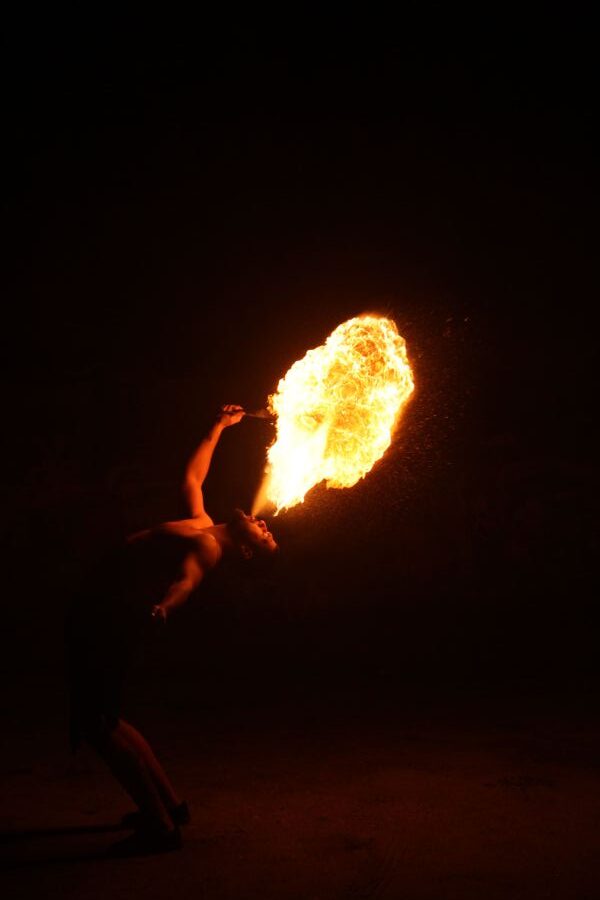 Artista a cuspir fogo durante um espetáculo noturno